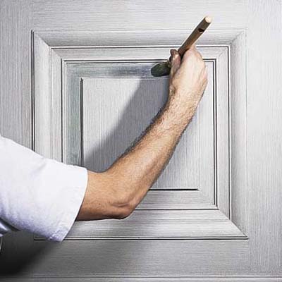 Small glazing brush applying second tinted glaze to recessed panel areas.
