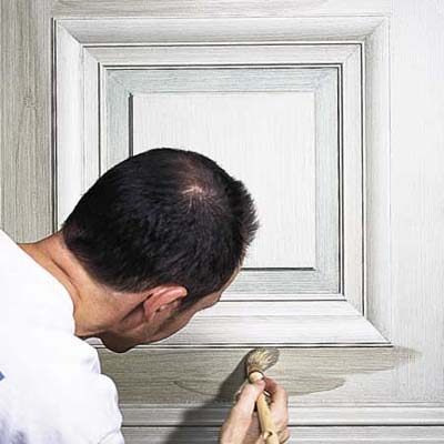 Person painting rails and stiles with second coat of first glaze color.
