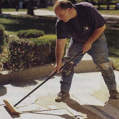 Man brushing a walkway.
