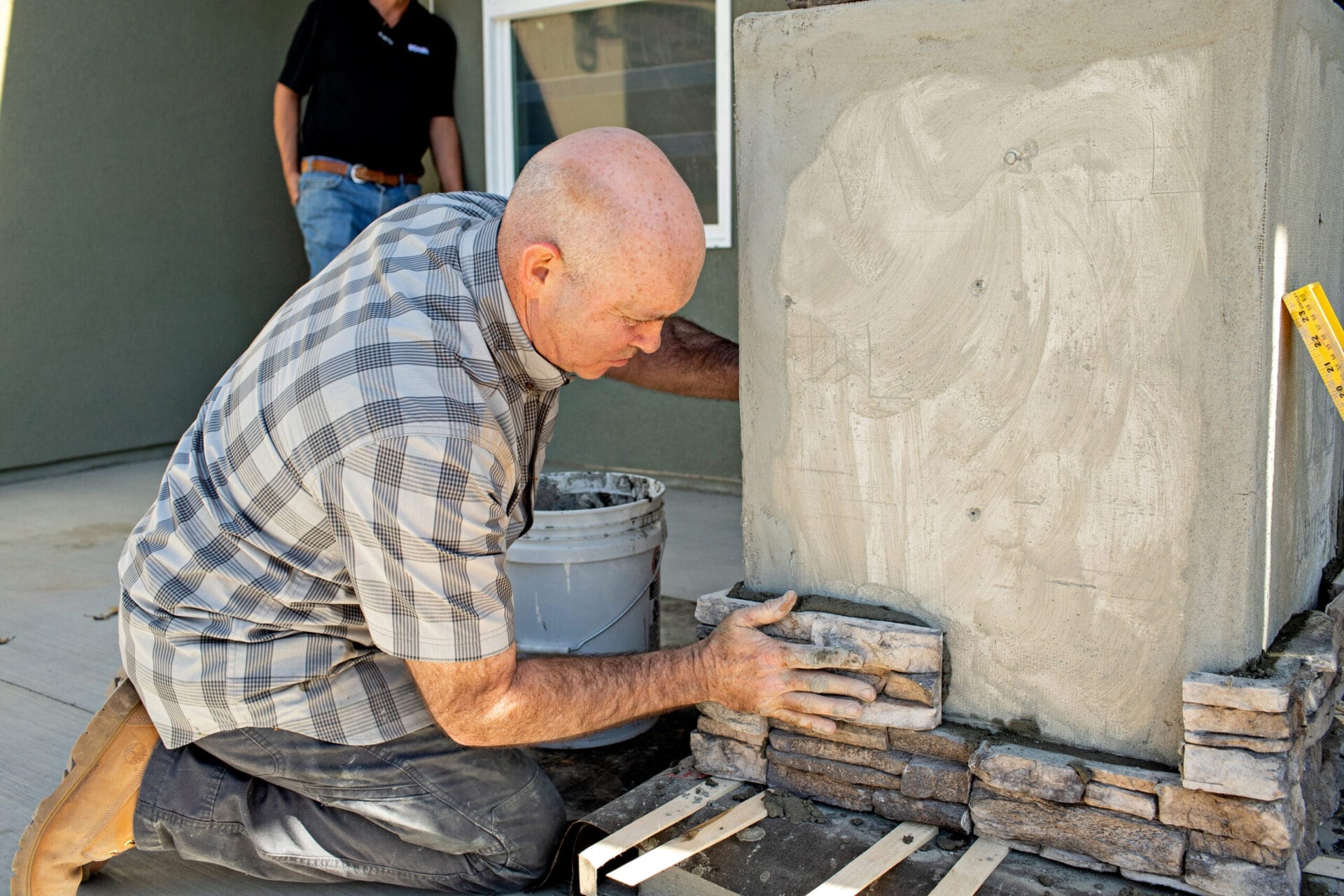 Stone veneer being installed on new home's exterior for fire resistance.