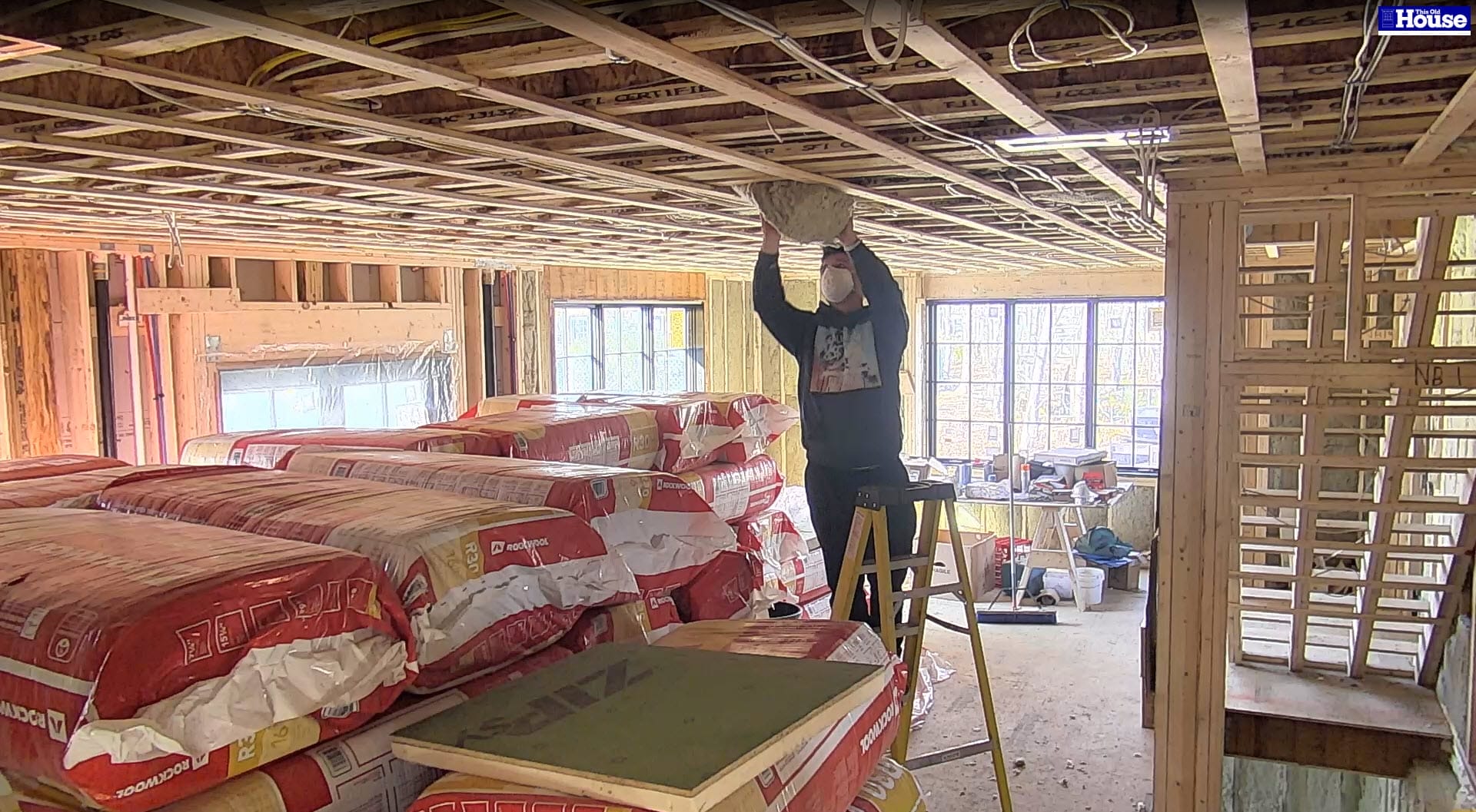 A worker installing mineral wool insulation.