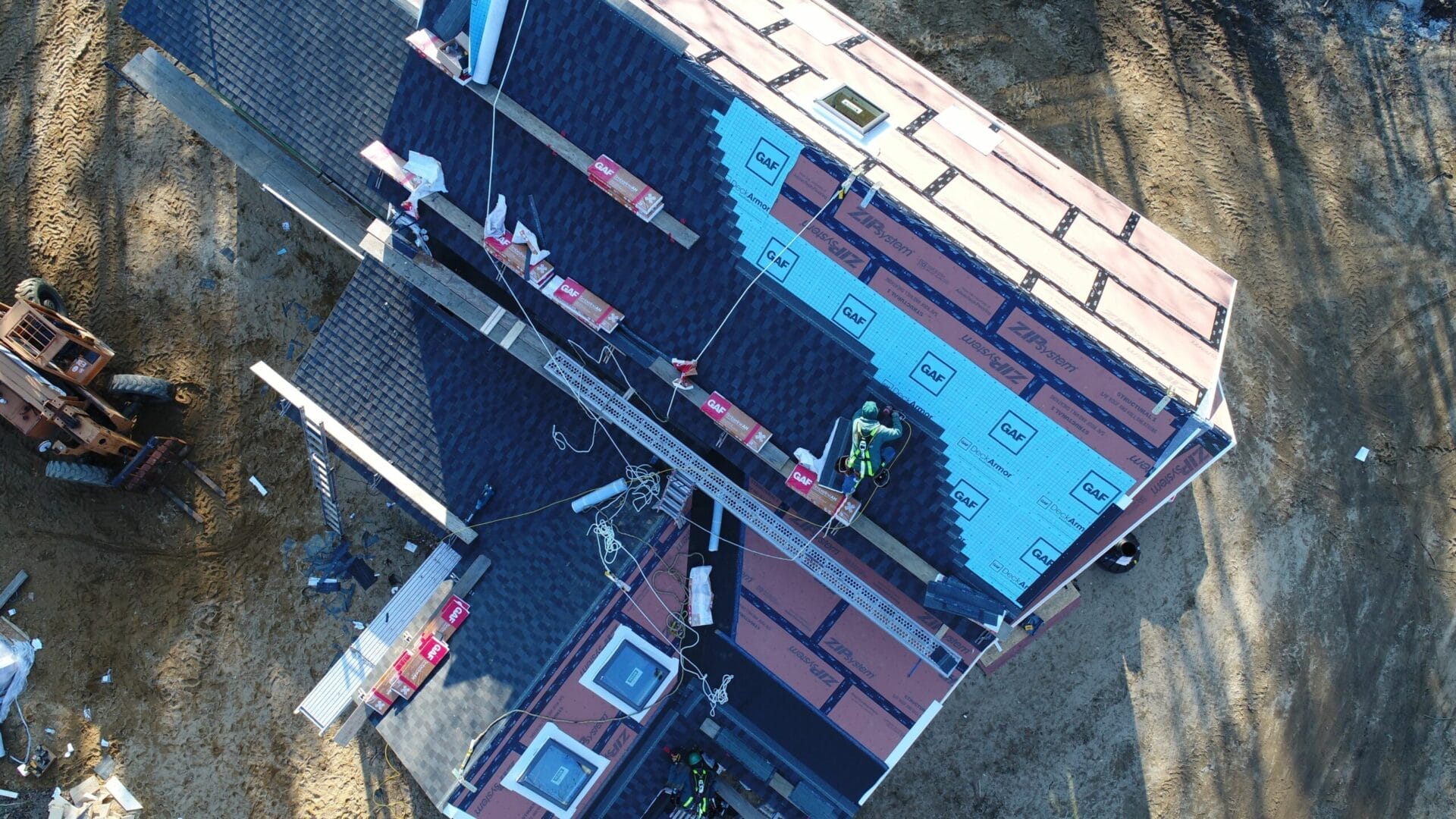 Roofers installing shingles on a house.