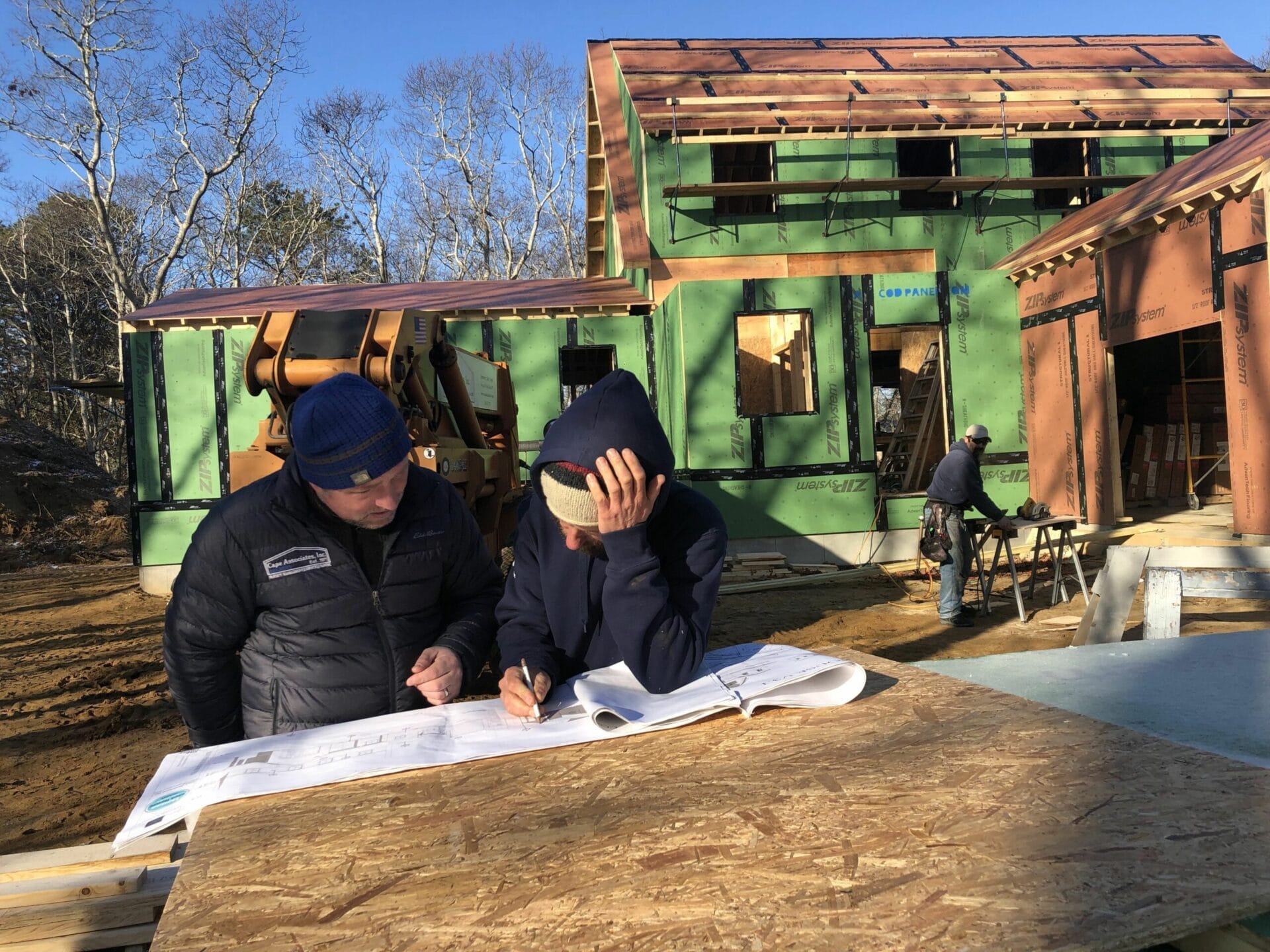 Crew members go over house plans.