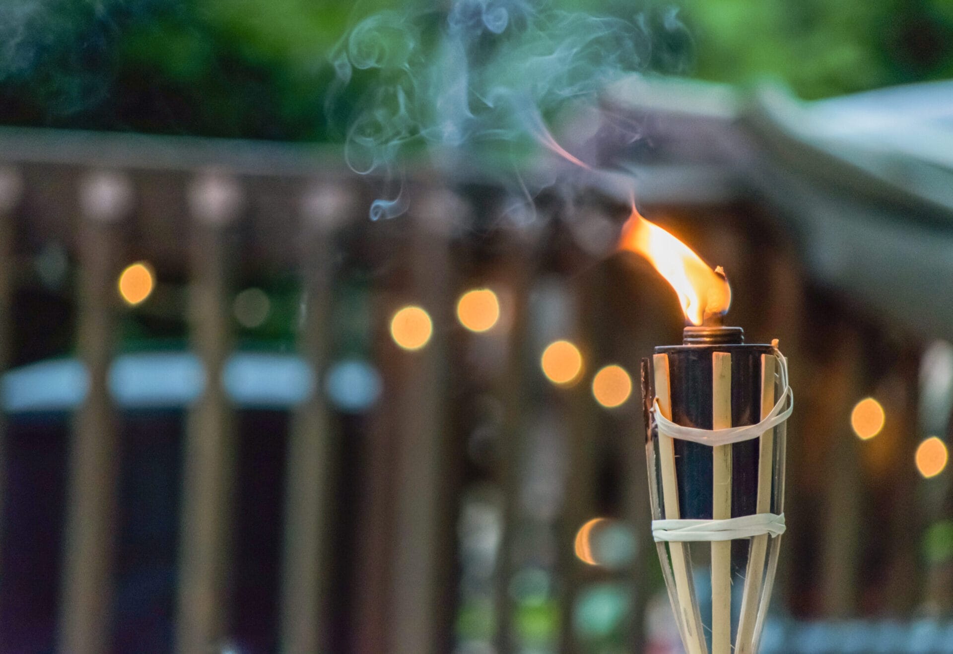 a tiki torch in a backyard that is lit
