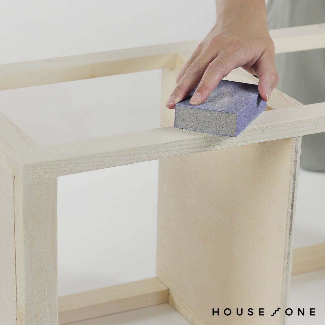 sanding the wood to prepare to stain the bathroom organizer