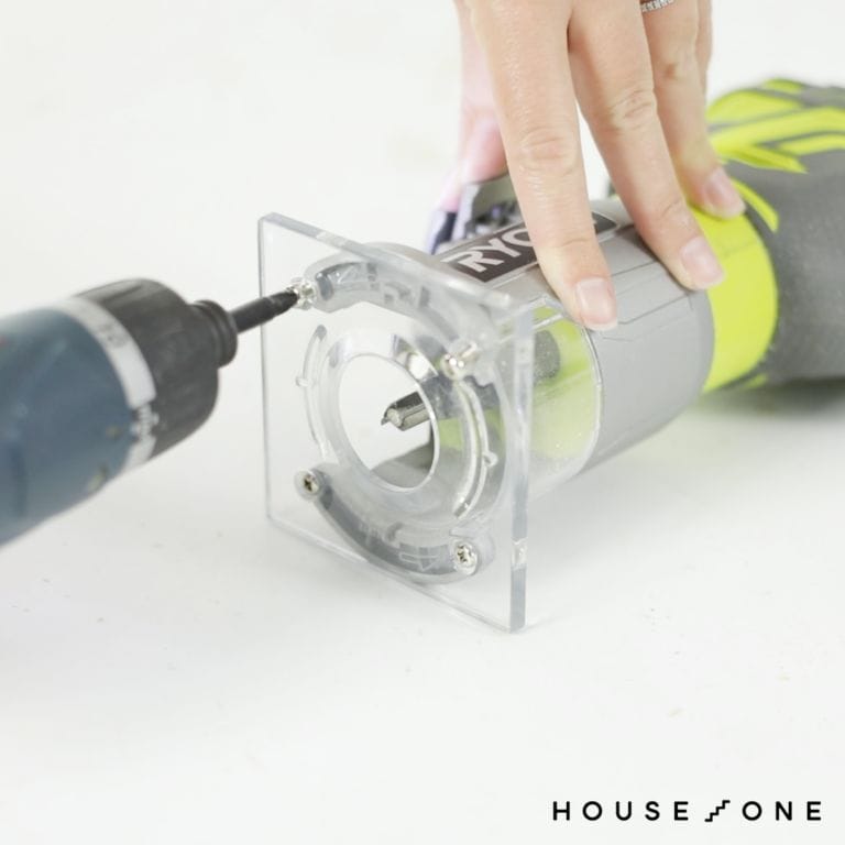 A drill is used to remove the router footplate to create a DIY circle jig.