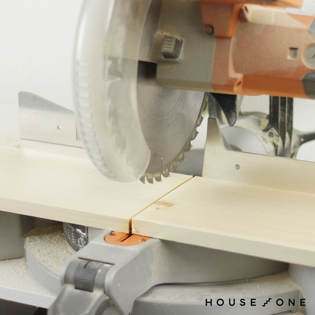 Wood for floating shelves are cut to length with a miter saw.
