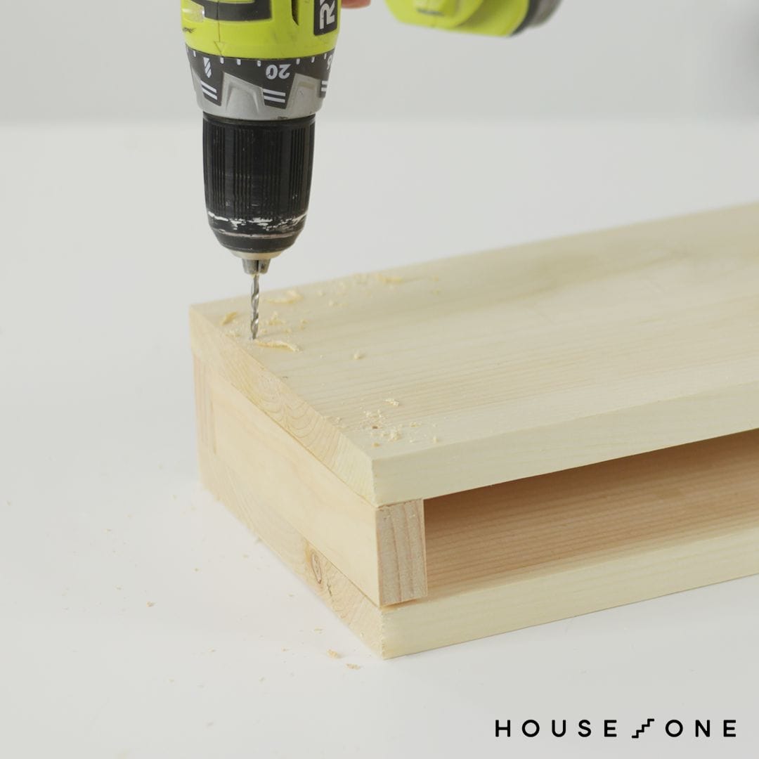 Pilot holes are drilled in the floating shelf.
