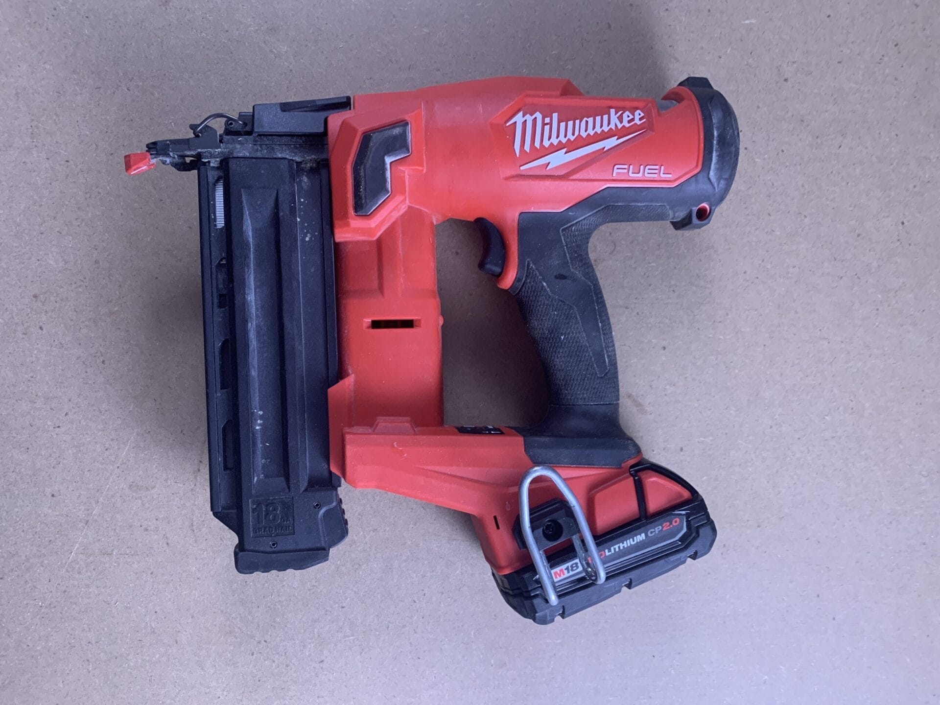 A red Milwaukee 18-gauge brad nailer.