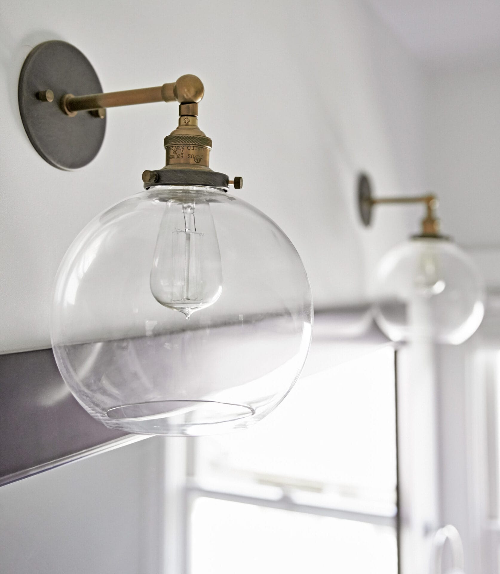 Two light fixtures over the sink of a small bathroom.