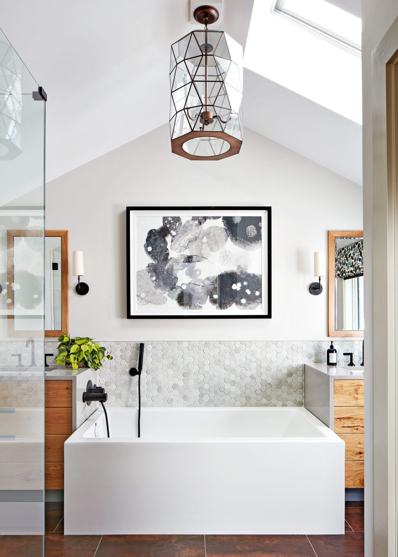 A small bathroom with a framed painting ang glass hanging light fixture.