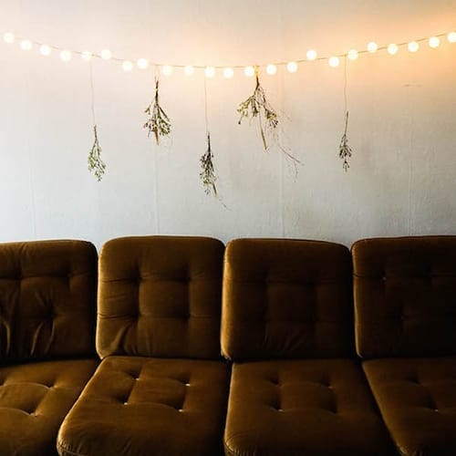 Ping pong light bulbs on a string over a couch.