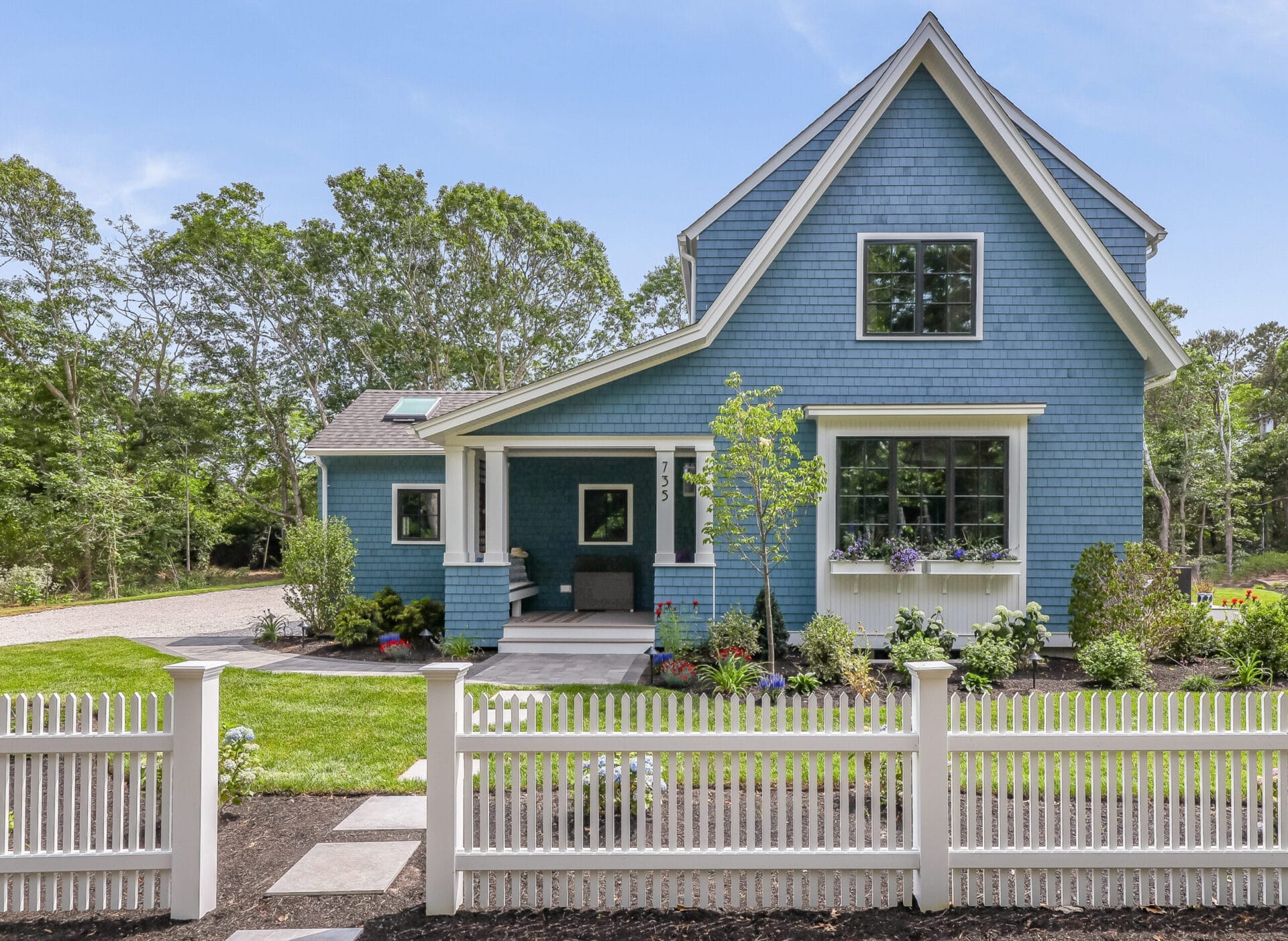 Front entrance detail with picket fence, side porch entry, window boxes, and Atlantic Blue cedar shingles.