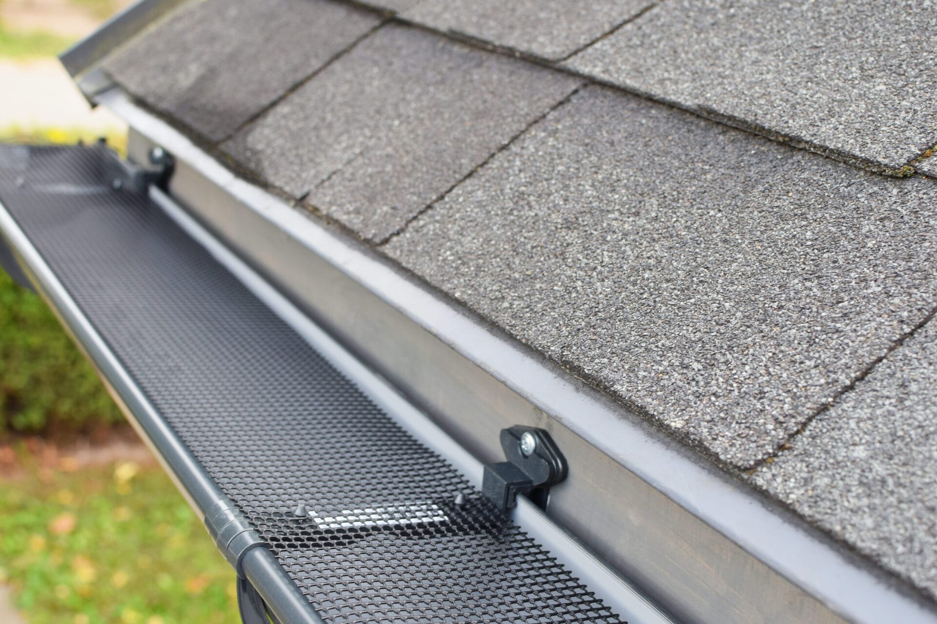 Black gutter guard system over home gutters.