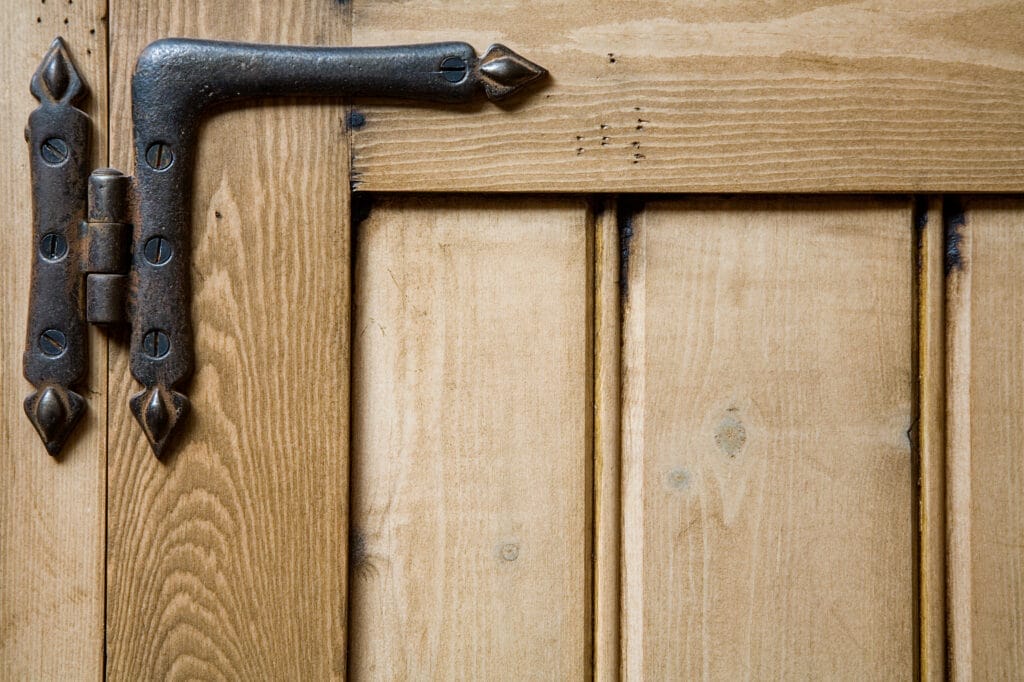 A hinge on the corner of a cabinet door.