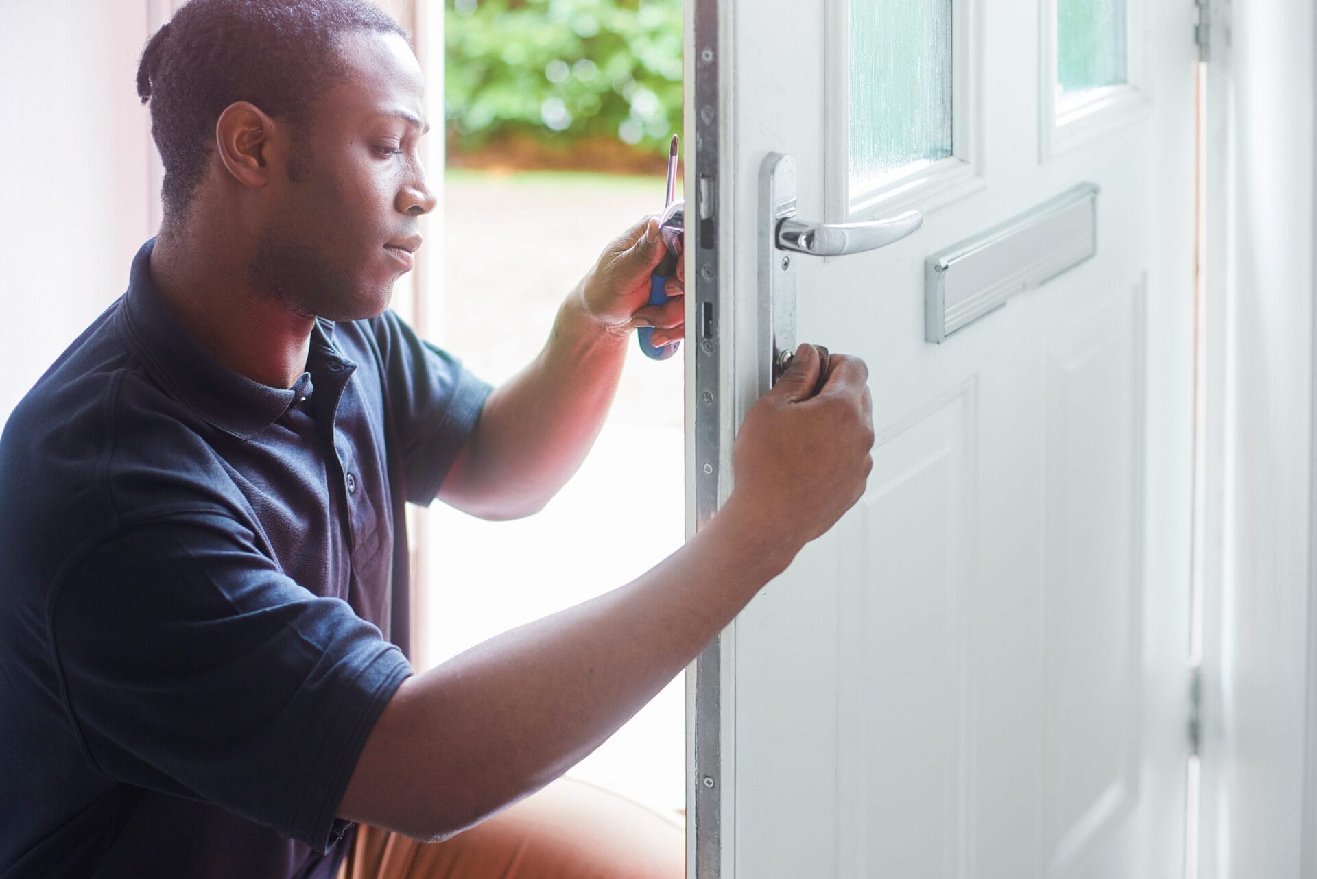 Person rekeying a lock on the door of a residential home