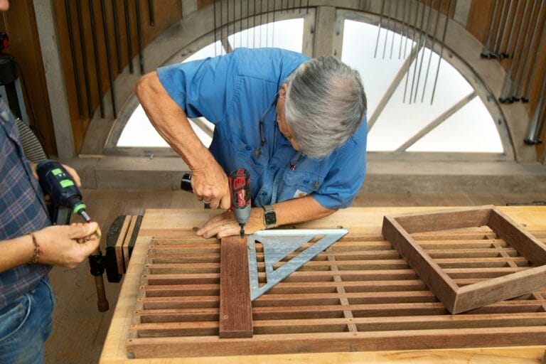 A man attaches the leg bases for a modern platform bench.