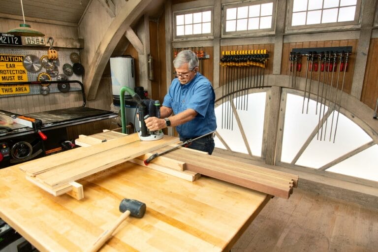 A man routes the slats for a modern platform bench.