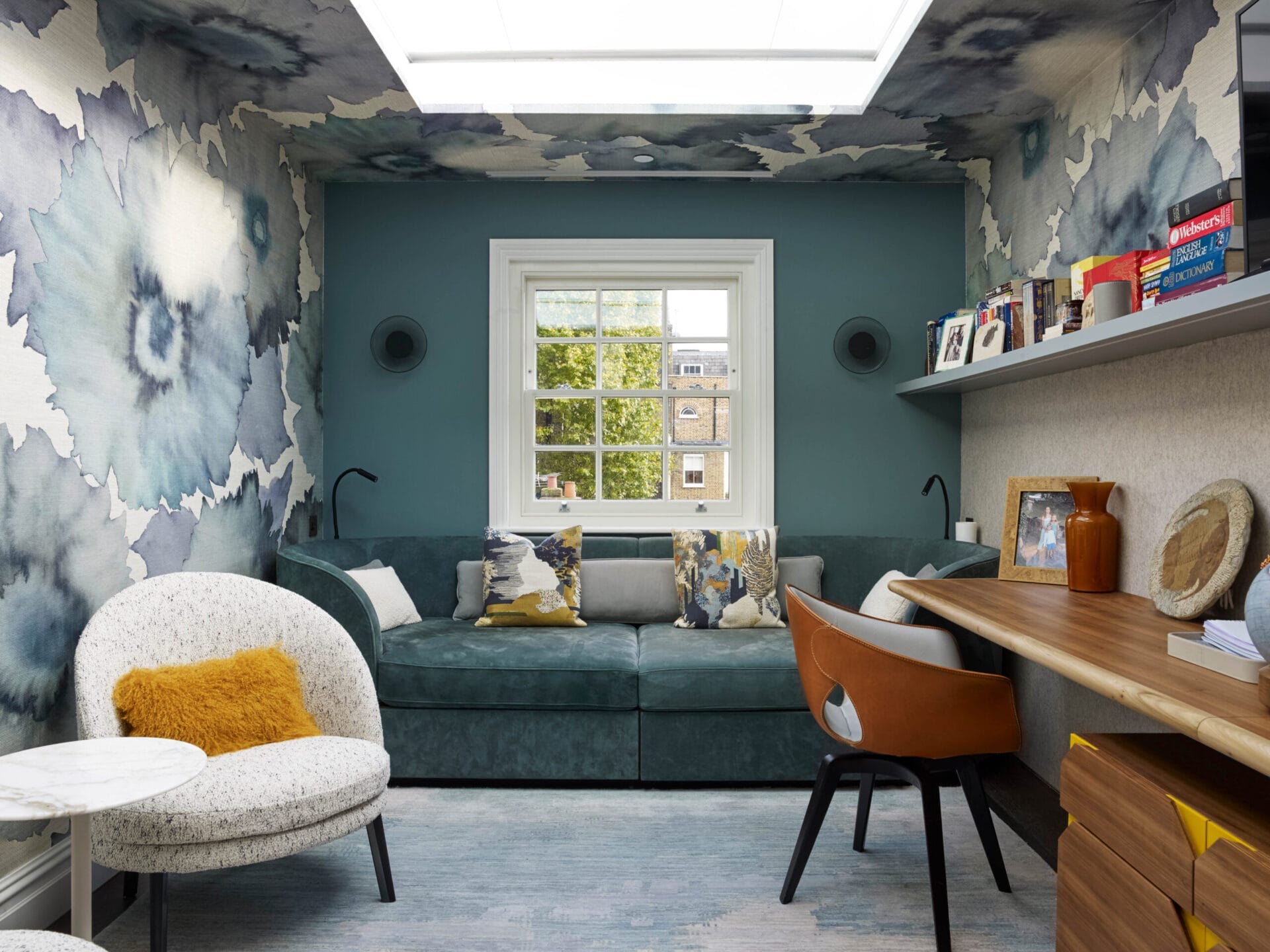 A small office with shelfing and a window looking into nature.