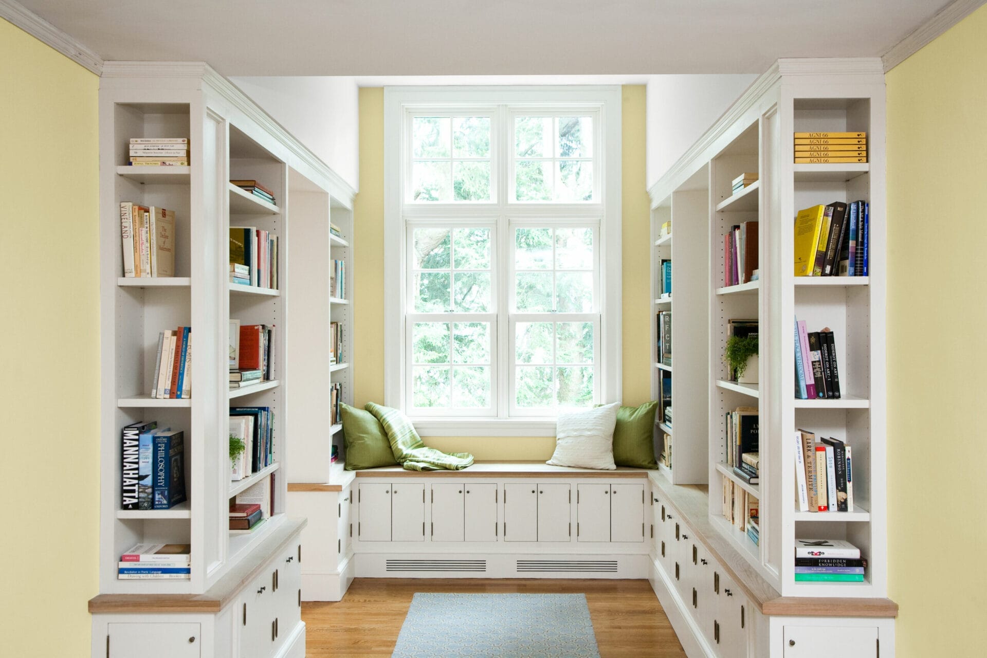 A nook with a seat by the window and a home library on either side.