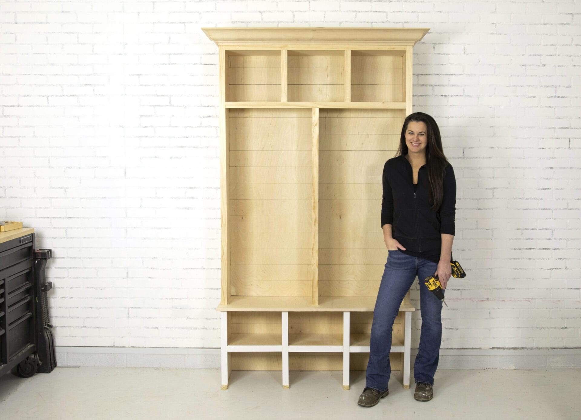 Jenn Largesse posed with mudroom storage cabinets she built.