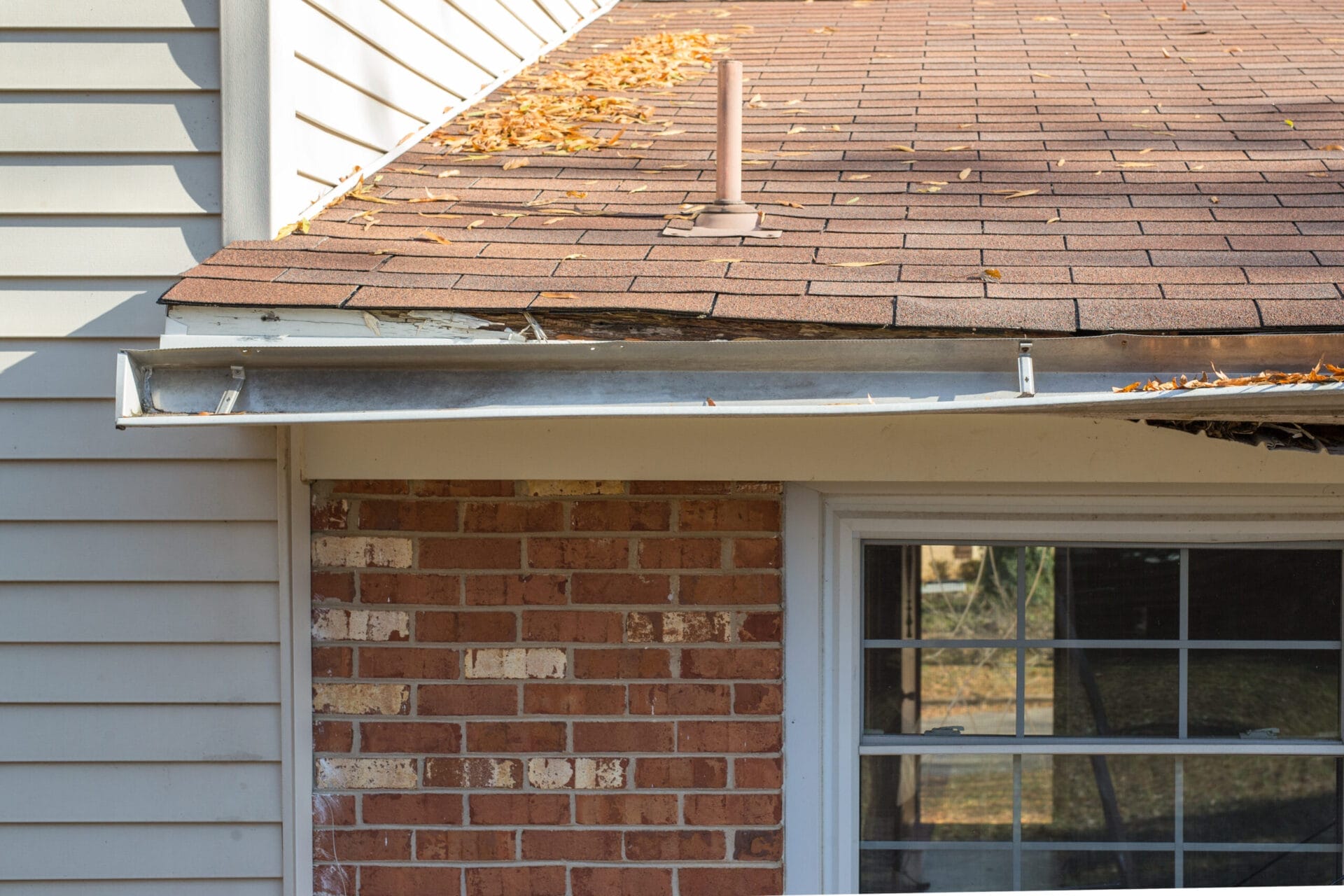 Rotten wood and gutters falling off a house.