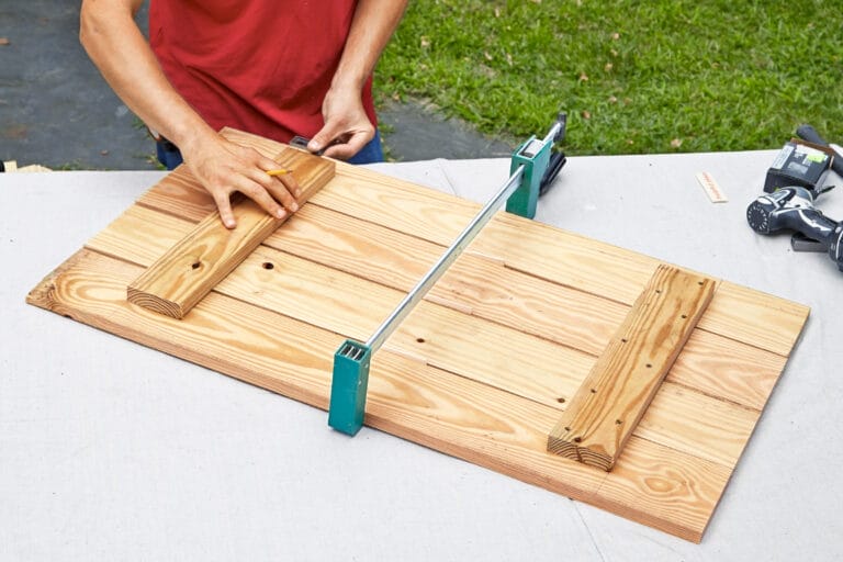Pieces of wood clamped together to make the side of a rain barrel.