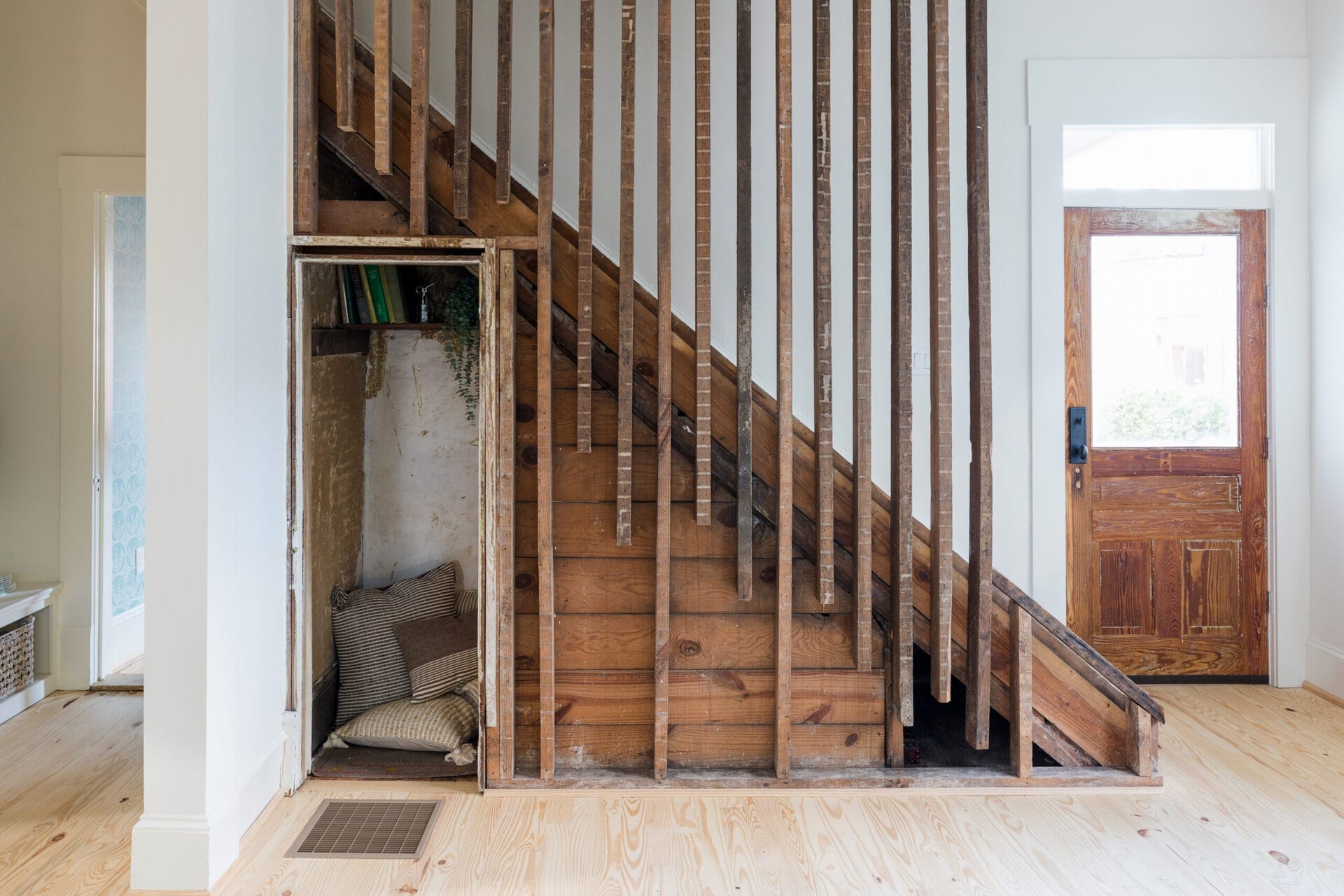 A home that used reclaimed wood as balusters and creates a cozy reading room under the stairs