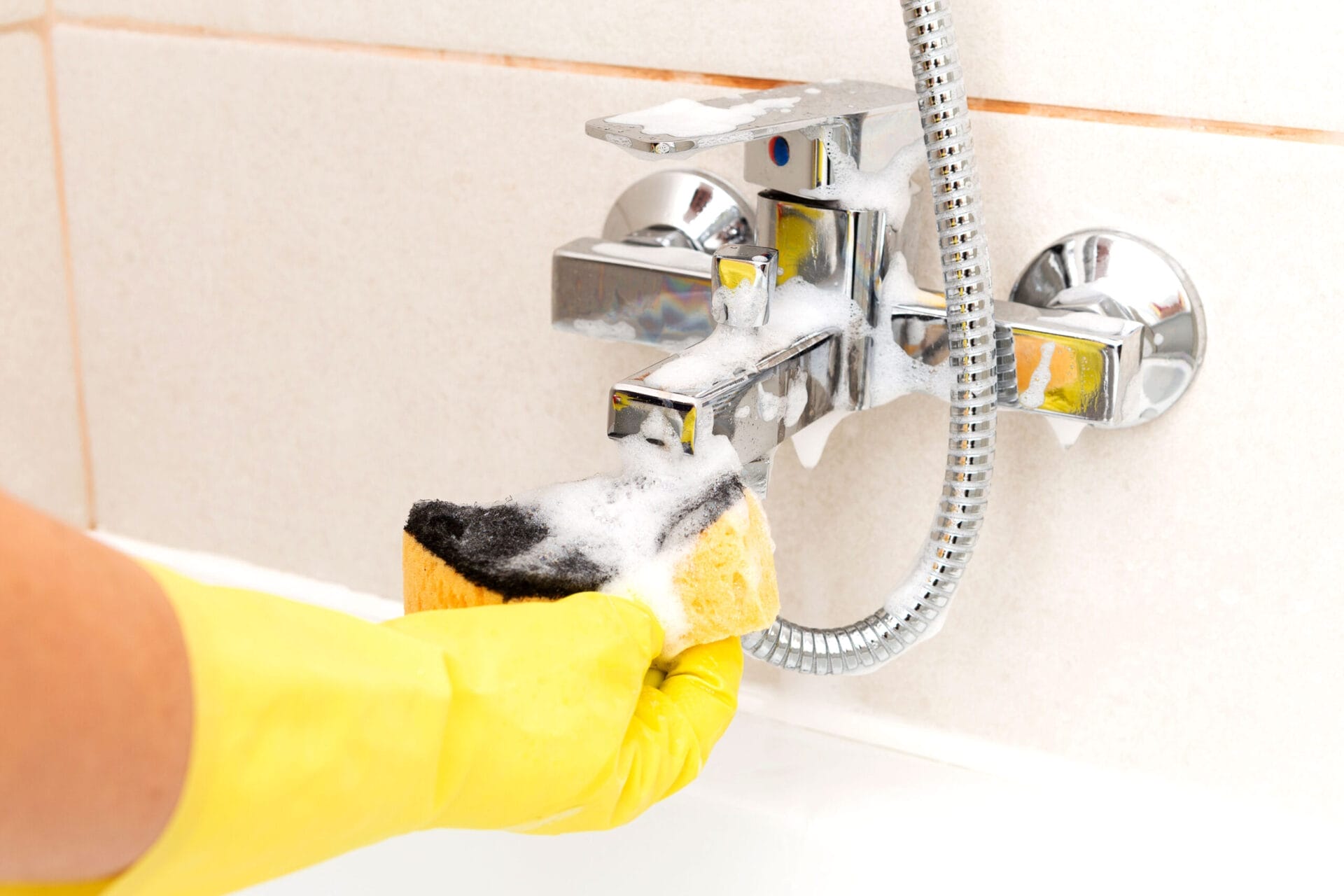 Sponge being used to clean water tap
