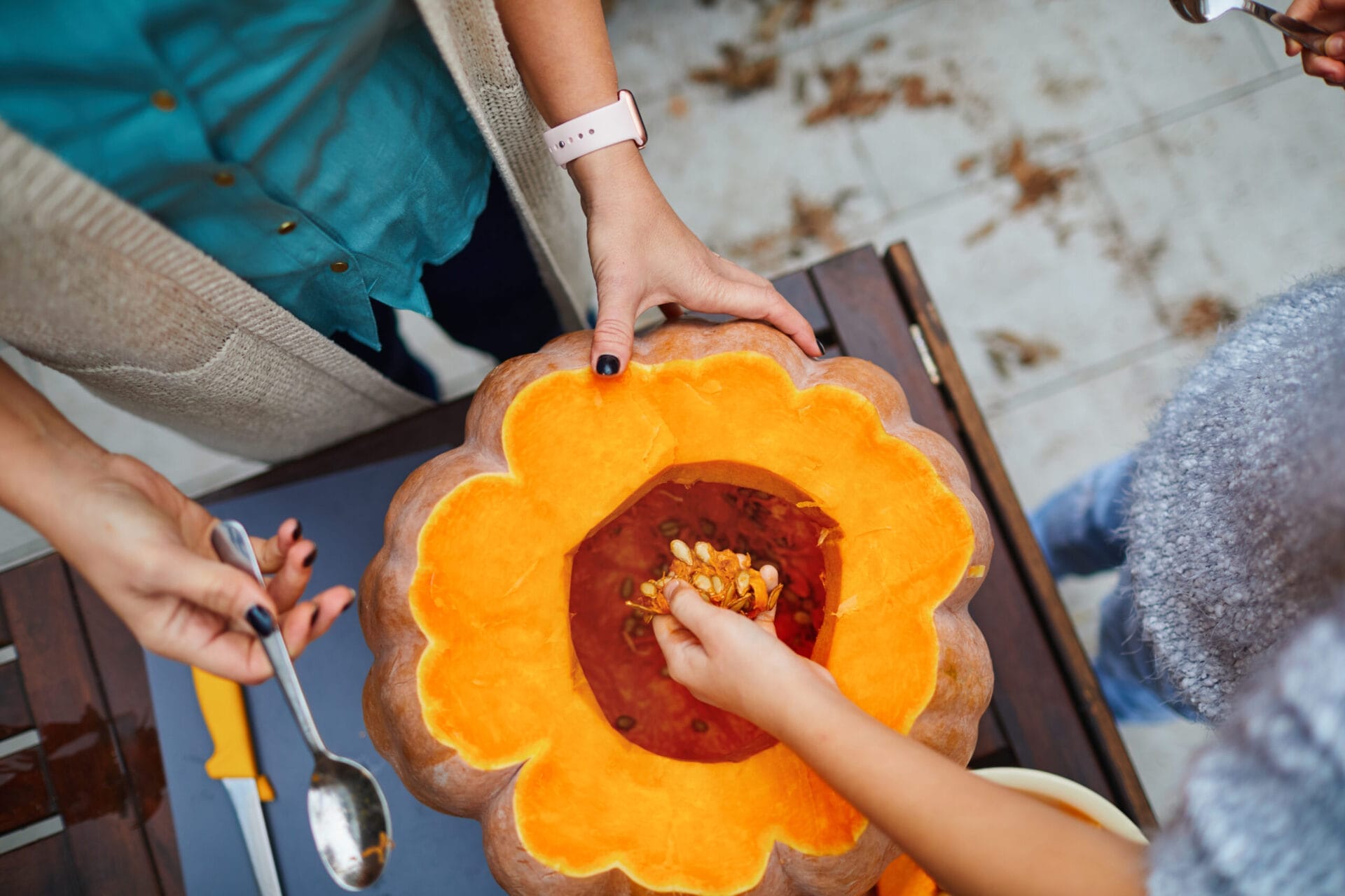 Mom and daughter removing seeds from an heirloom pumpkin
